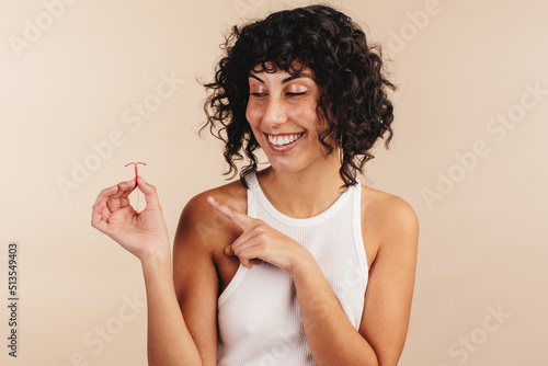 Cheerful woman choosing the copper IUD for contraception photo