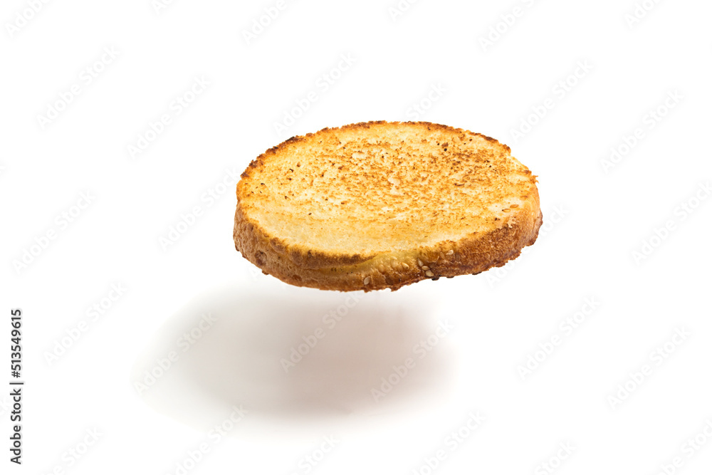 A floating slice of fried bread on a white background. Round flying toast. Isolated A floating slice of fried bread on a white background. Round flying toast. Isolated