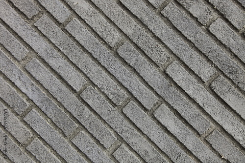 Textured background of a gray brick diagonal wall.