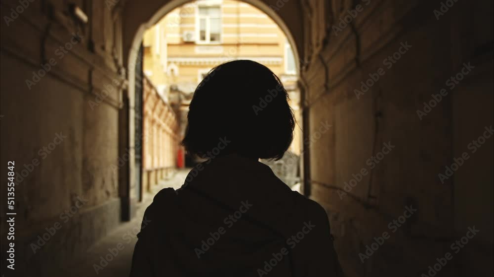 silhouette of a beautiful girl passing through the arch in the central part of the city of Kyiv. bob hairstyle back view. Slow Motion 100fps 2.8k silhouette of a beautiful girl passing through the arch in the central part of the city of Kyiv. bob hairstyle back view. Slow Motion 100fps 2.8k