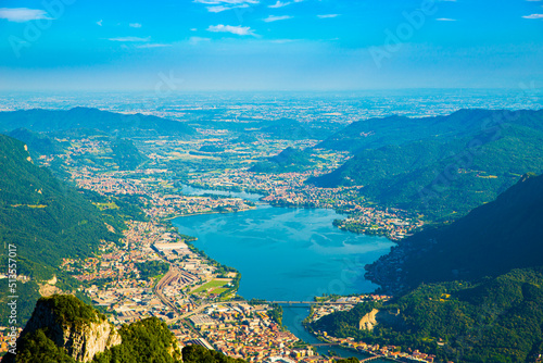 The city of lecco, shot from above, by day, with the surrounding mountains. 