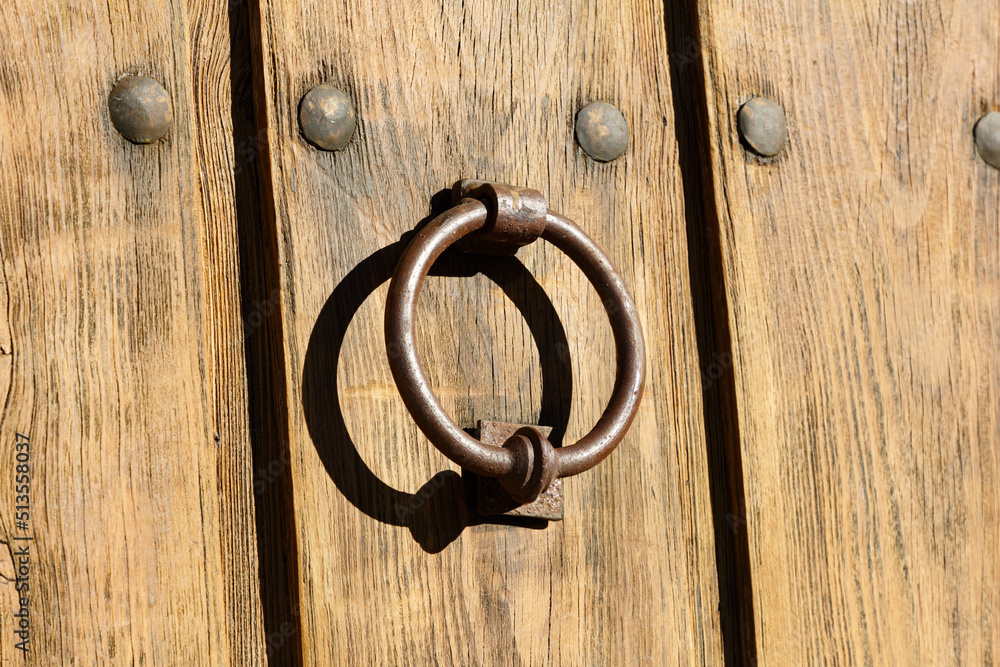 Close-up of a metal ring on an old wooden front door. Close-up of a metal ring on an old wooden front door.