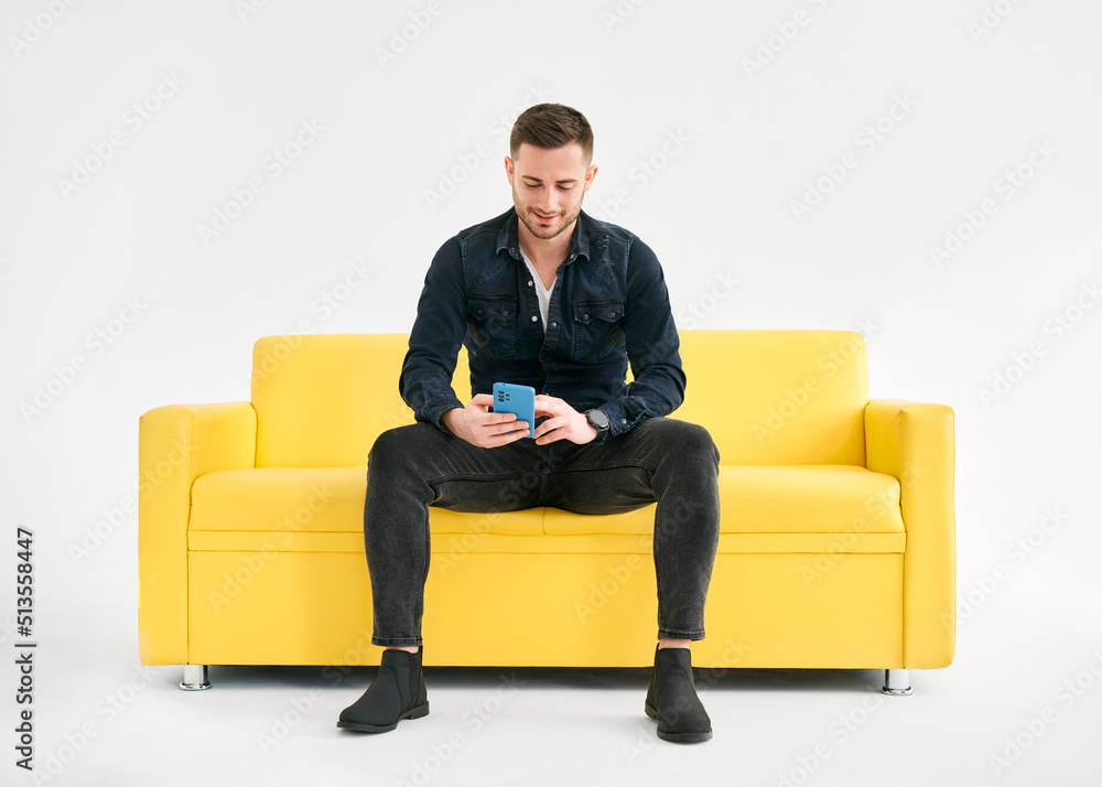 Relaxed man sitting on couch using hsi mobile smart phone Relaxed man sitting on couch using hsi mobile smart phone