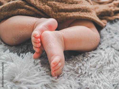 Cute feet of sleeping newborn baby in light bedroom.Top view Baby's legs.