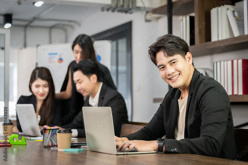 Asian businessman looking at the camera Working and meeting at the office at the company with colleagues at the back Asian businessman looking at the camera Working and meeting at the office at the company with colleagues at the back