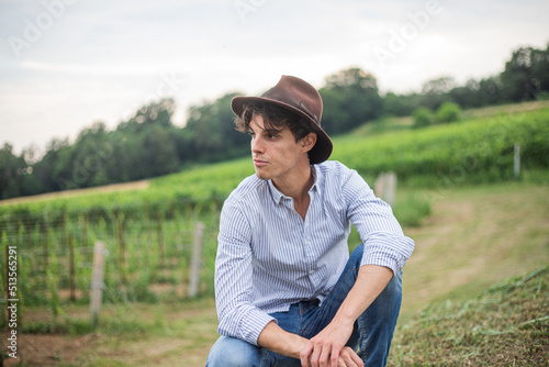 Fototapeta Boy wearing a country hat on vacation visits vineyards where he gets beautiful p