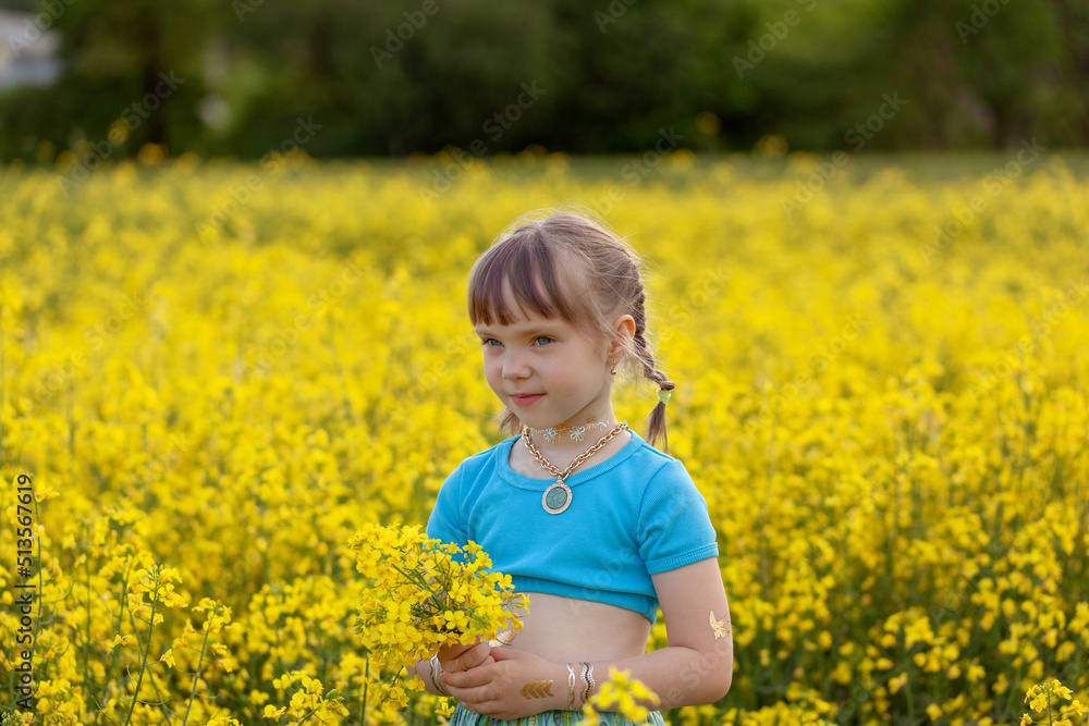 Portrait cute girl with a yellow bouquet of rape flowers in summer on a meadow background. Sweet child with flowers bunch in hands. Portrait cute girl with a yellow bouquet of rape flowers in summer on a meadow background. Sweet child with flowers bunch in hands.