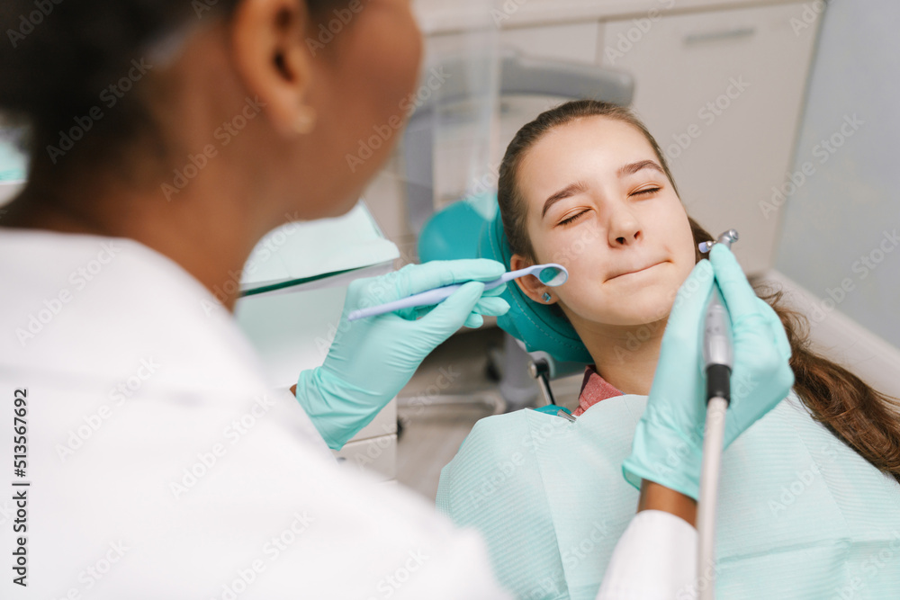 Black dentist working with patient in dental clinic Black dentist working with patient in dental clinic