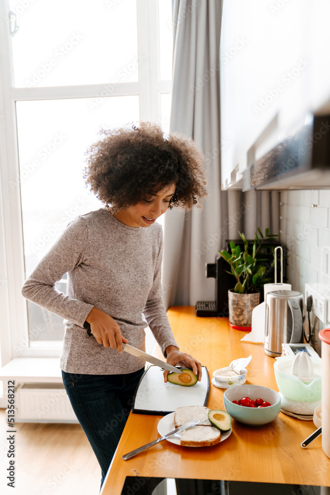 African american young woman making breakfast in morning at home