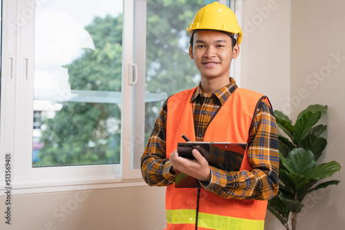 Asian inspector checking structure of new property and taking note in the clipboard for review and fix the house before sell to client