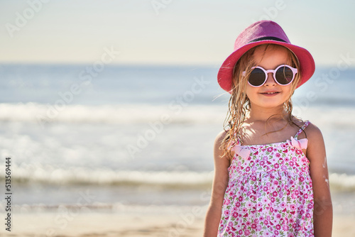 portrait of a girl with cap and sunglasses at the beach