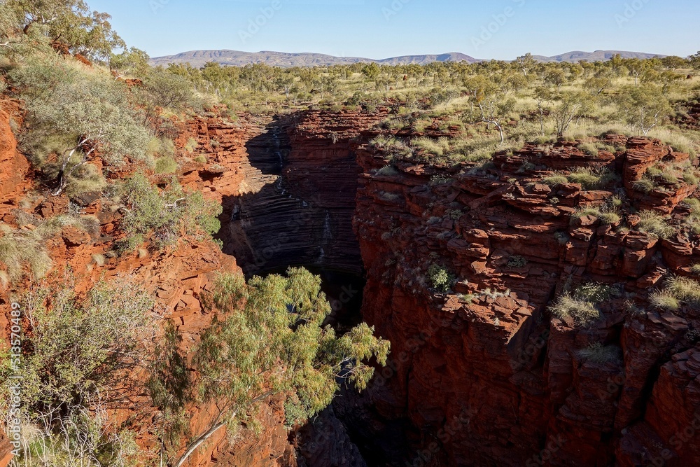 Joffre Gorge in Karijini National Park in Western Australia at afternoon with a creek below