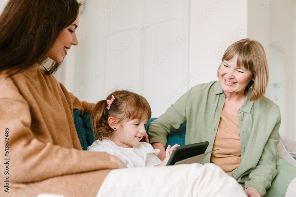 Obraz premium White girl using tablet computer while spending time with her family