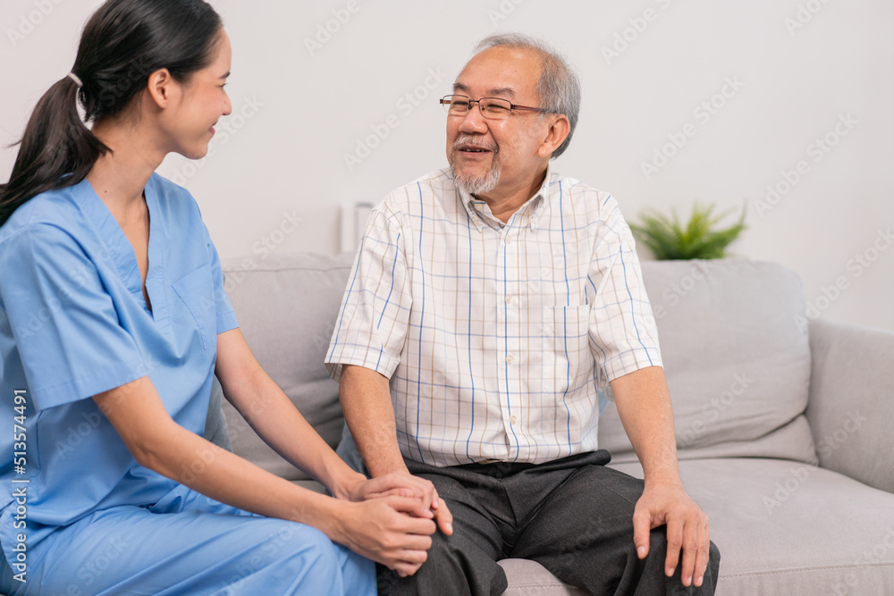 Obraz premium Young Asian nurse hands on senior man to giving support empathy in assisted living home care mental. medical consult and physical therapy to elderly patient at home nursing.