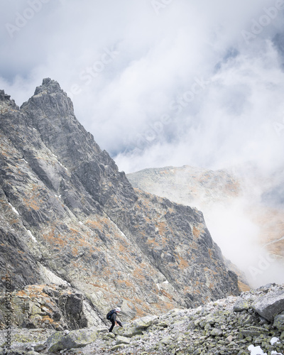 Mountain climber walking rocky ridge high up amongst the clouds , Slovakia, Europe