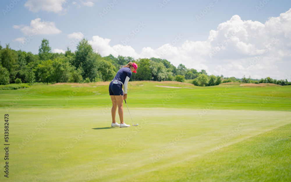 GOLF. Woman playing golf on a golf course in the sun GOLF. Woman playing golf on a golf course in the sun