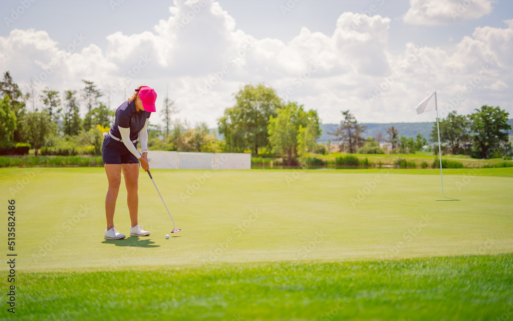 Fototapeta premium GOLF. Woman playing golf on a golf course in the sun