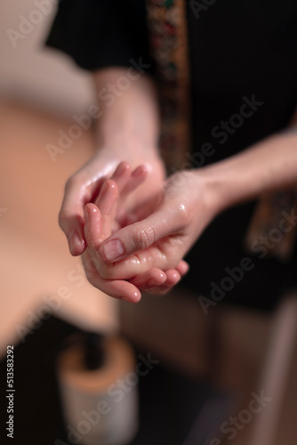 A masseuse rubs her hands in oil