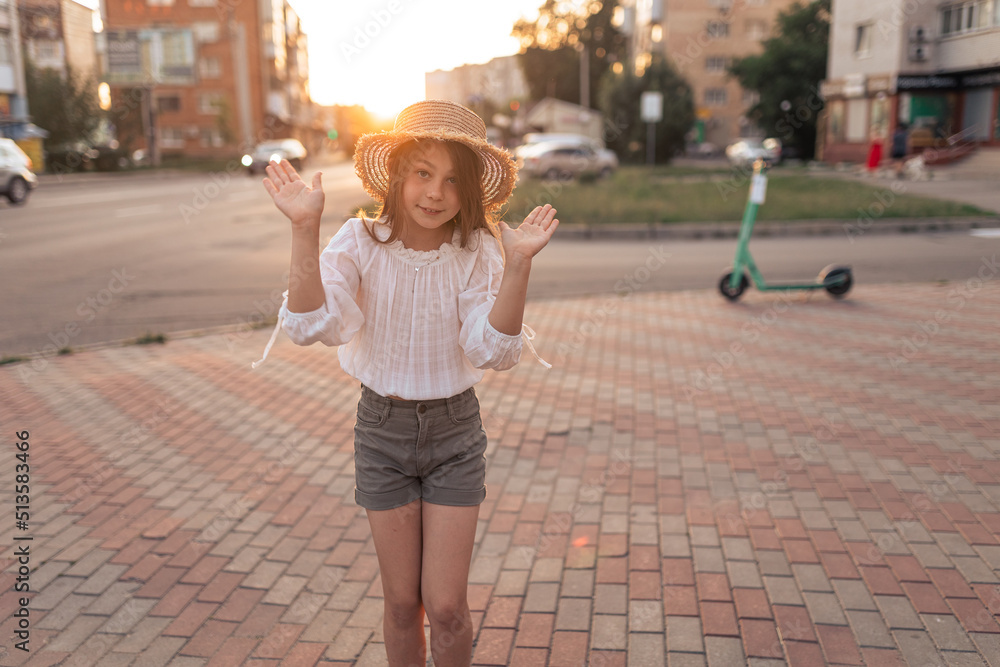 Cute little girl in a straw hat outdoors in summer