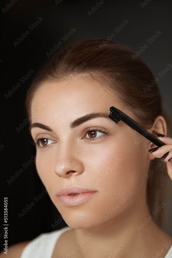 Beauty makeup. Eyebrows Care and  makeup. Portrait of beautiful woman model shaping brown eyebrows.