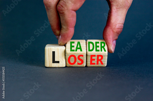 Loser or leader symbol. Concept words Loser or leader on wooden cubes. Businessman hand. Beautiful grey table grey background. Business and loser or leader concept. Copy space.