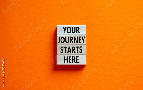 Your journey starts here symbol. Concept words Your journey starts here on wooden blocks on a beautiful orange table orange background. Business, motivational and your journey starts here concept.