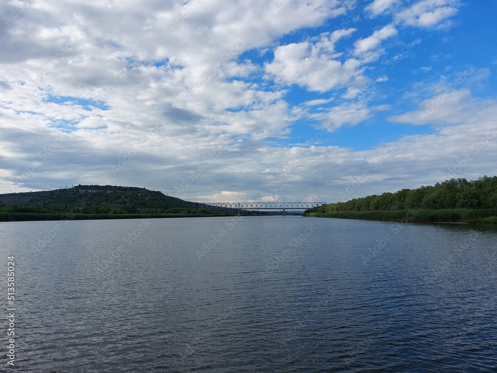 View from the middle of the river to the hilly banks overgrown with forest