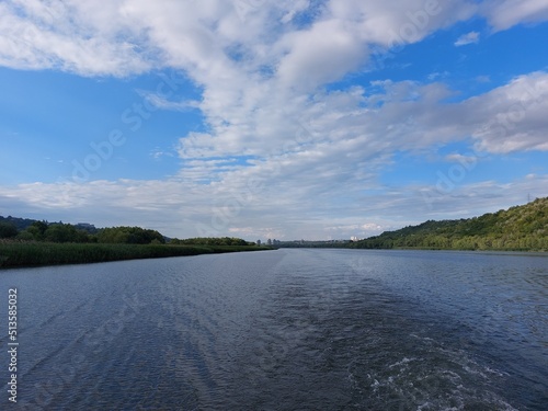 View from the middle of the river to the hilly banks overgrown with forest