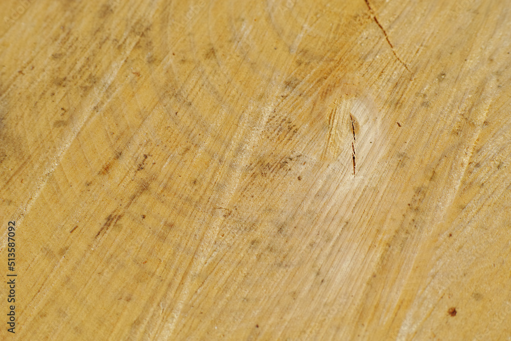 Closeup of scratches on old wood. Detail of rough textures on a used chopping board. Wooden material with carving marks. Grunge patterns on an antique desk or cooking table.