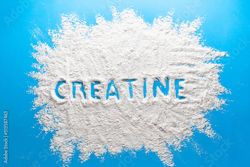 Scattered powder with the word creatine written on it on a blue background.