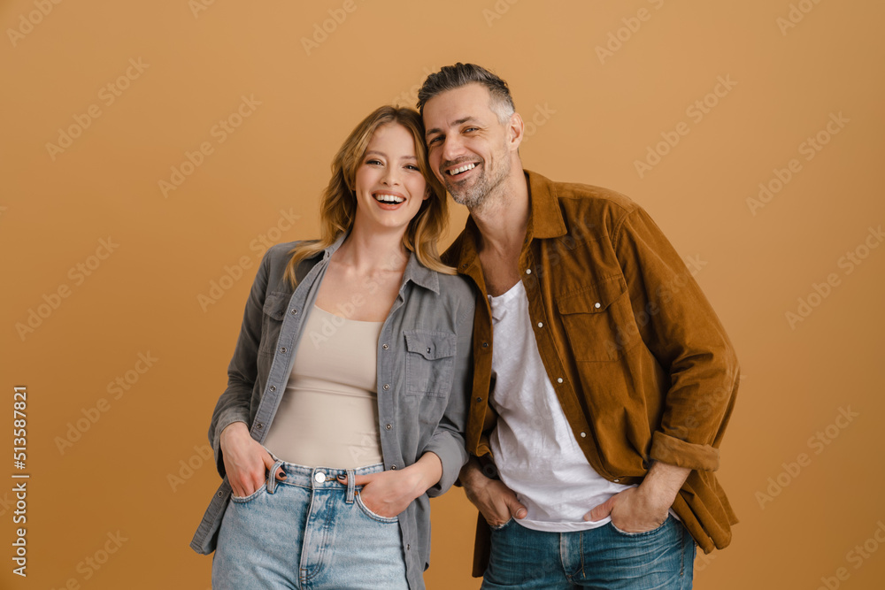 White happy couple wearing shirts smiling and looking at camera White happy couple wearing shirts smiling and looking at camera