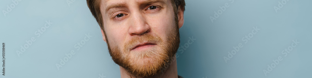 Obraz premium White ginger man with beard frowning and looking at camera