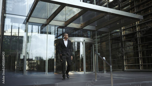 Adult african american businessman wearing suit walking outdoors