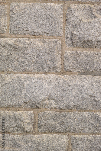 Closeup of granite stone wall outside in a city during the day. Macro view of detail and texture on historic, strong and sturdy exterior downtown. Walled pattern on a castle or old, ancient building