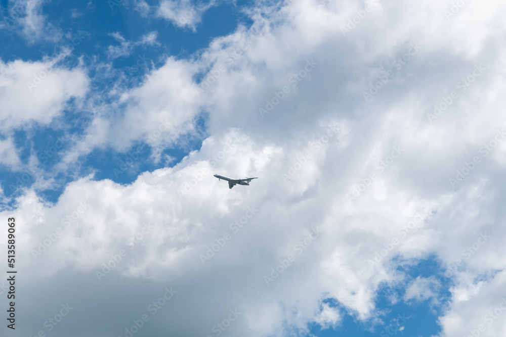 in a blue sky with beautiful clouds flies an airplane