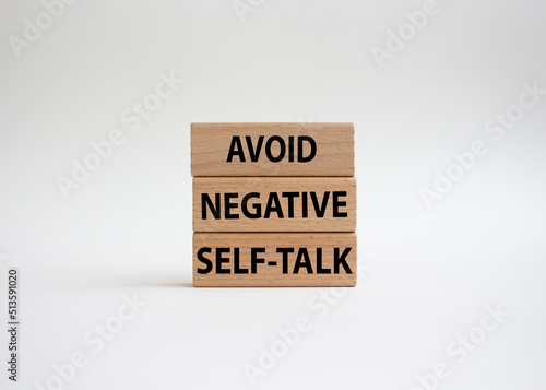Avoid negative self-talk symbol. Concept words Avoid negative self-talk on wooden blocks. Beautiful white background. Business and Avoid negative self-talk concept. Copy space.