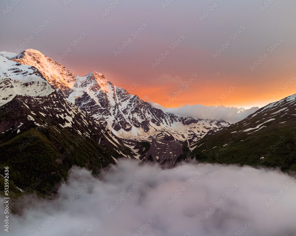 Beautiful mountain landscape. Alpine climbing. Sunset in the mountains. Dramatic clouds. The Caucasus is a region spanning Europe and Asia. Elbrus region. Aerial view to the mountains in summer. 