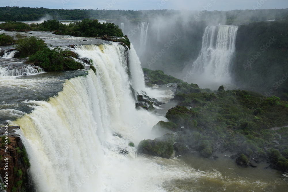 The photo shows a stunning view from the top of the Iguazu Falls — a complex of 275 waterfalls on the Iguazu River, located on the border of Brazil and Argentina. The photo shows a stunning view from the top of the Iguazu Falls — a complex of 275 waterfalls on the Iguazu River, located on the border of Brazil and Argentina.