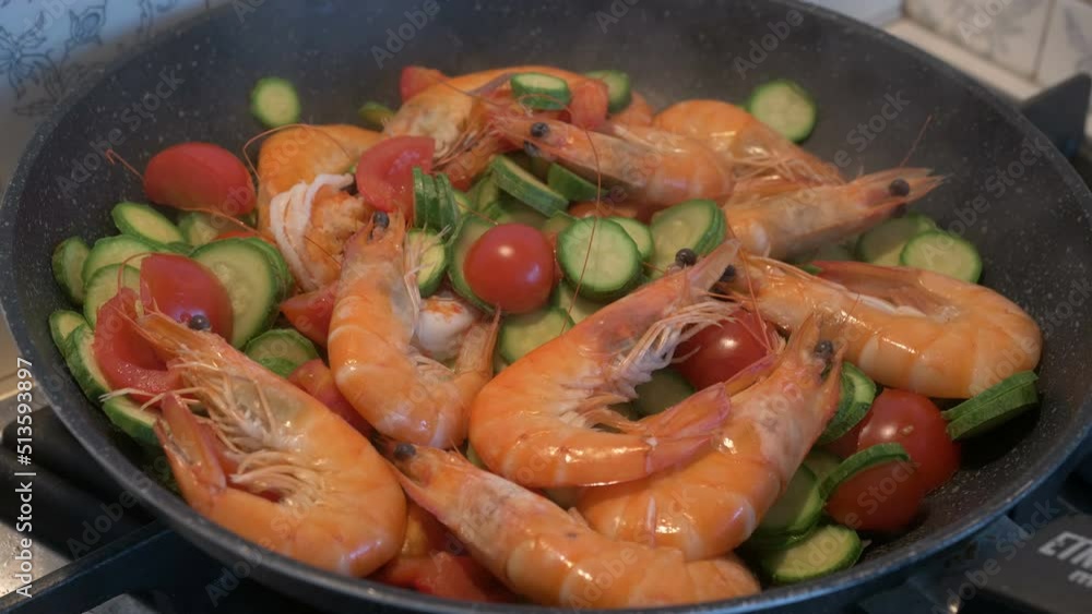 Sauteed shrimp, courgettes, and cherry tomatoes, in a steaming pan Sauteed shrimp, courgettes, and cherry tomatoes, in a steaming pan