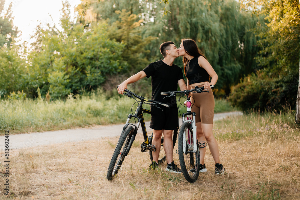 young couple riding a bicycle in the park young couple riding a bicycle in the park