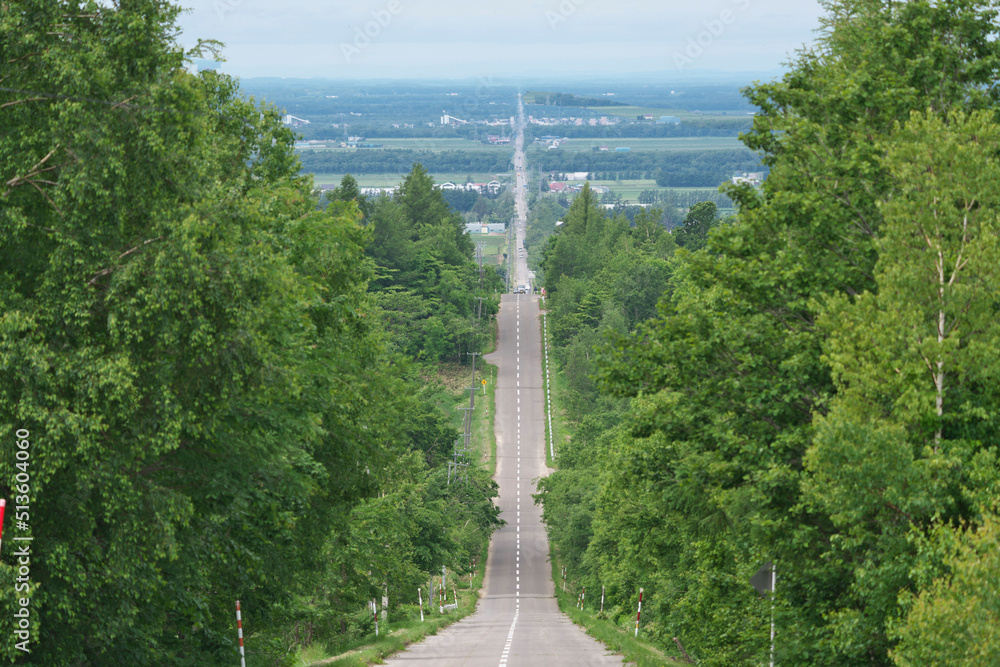 Hokkaido,Japan - June 23, 2022: Road to Heaven viewed from the hill in Shari town. Straight road in Shiretoko, Hokkaido, Japan
