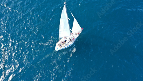 Aerial drone photo of beautiful sail boat anchored in deep blue open ocean sea