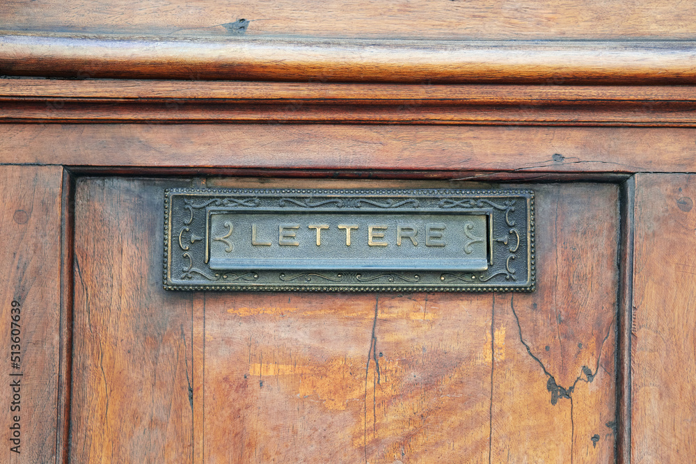 Italian classic local domestic mailbox as door gap slot made in old wooden door
