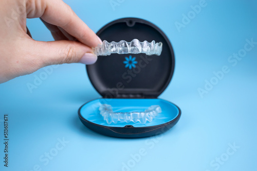 Print op canvas Woman holding invisalign transparent retainers with a box on the table, flatlay top view