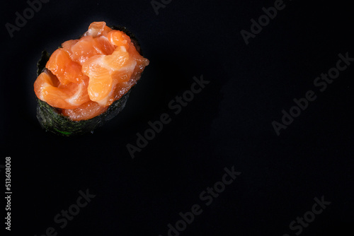 Salmon tartare gunkan maki sushi with fresh raw salmon with copy space on black background