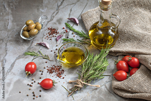 Ingredients for Mediterranean cuisine: olives and olive oil, fresh and dried tomatoes, rosemary, multicolored pepper, garlic. Ingredients for the Mediterranean diet. Natural background