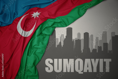 abstract silhouette of the city with text Sumgait near waving national flag of azerbaijan on a gray background.
