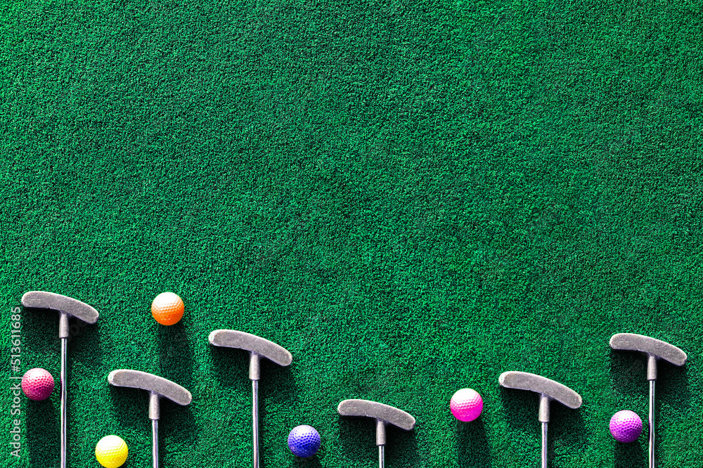 Multiple mini golf clubs and balls on putting green background with copy space - obrazy, fototapety, plakaty 
