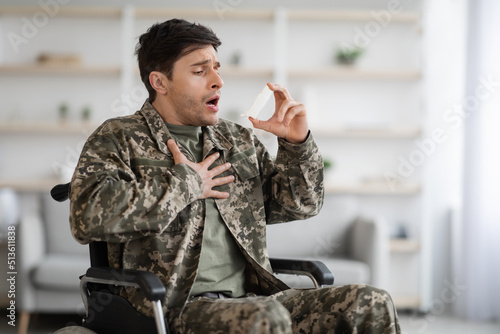 Injured military man suffering from panic attack, using inhaler