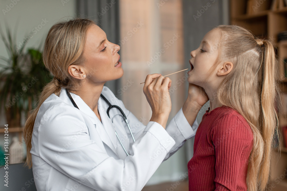 Angina, tonsillitis, cold and flu in children concept. Female doctor pediatrician checking patient little girl throat Angina, tonsillitis, cold and flu in children concept. Female doctor pediatrician checking patient little girl throat